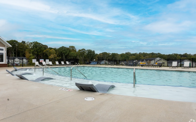 Pool area with lounge chairs in the water at Wayford at Innovation Park luxury townhome in Charlotte. 